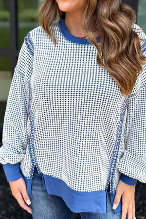 Light blue sweatshirt with contrast stitching, crew neck, and side slits.