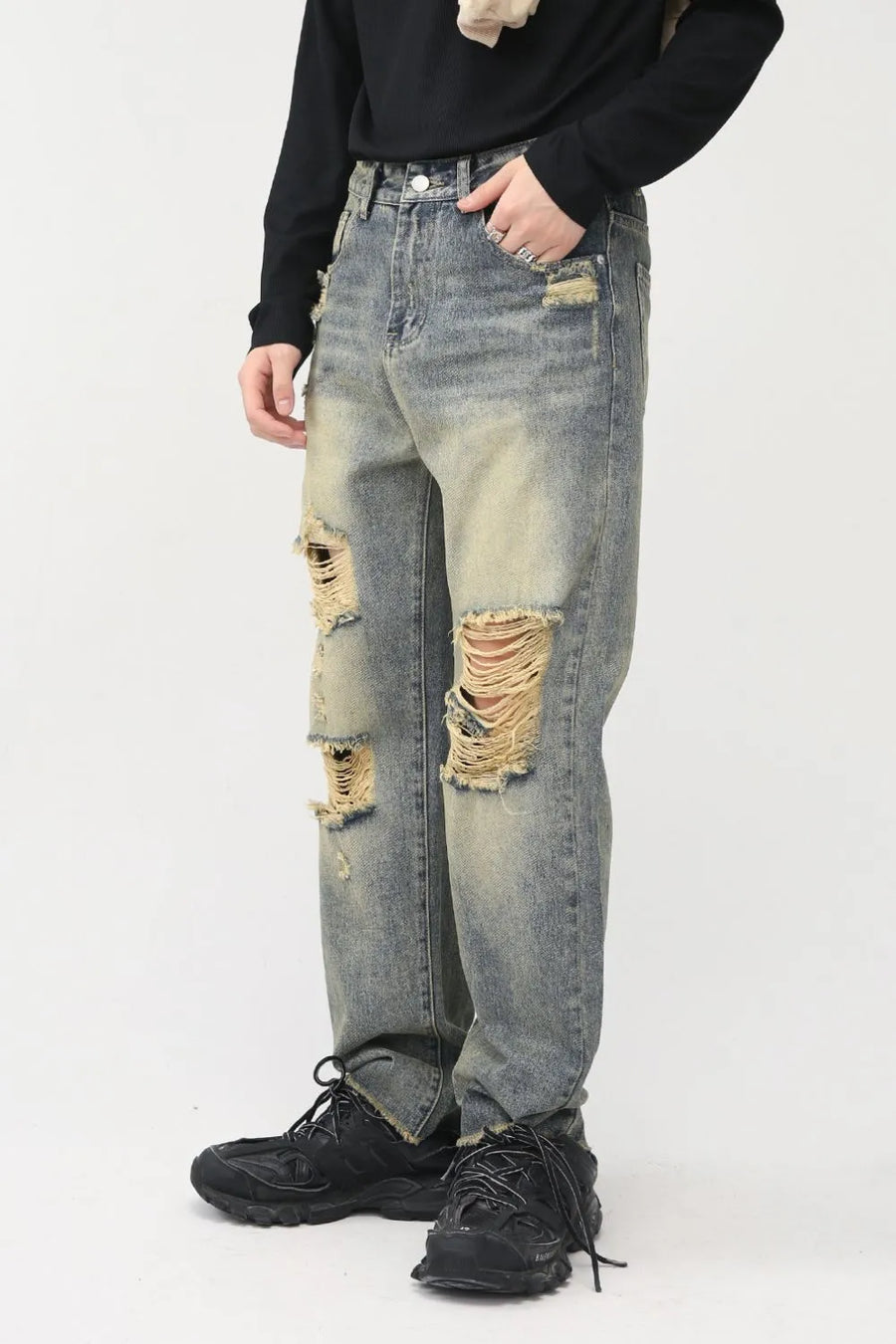 Distressed baggy denim jeans in medium wash with shredded knees and a casual fit.
