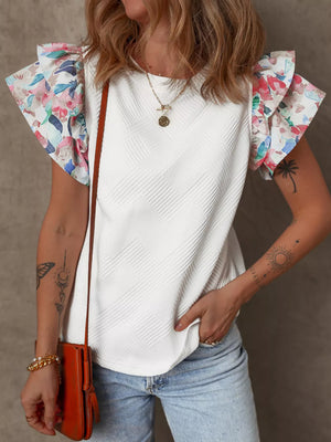 White geometric knit top with floral ruffled sleeves and round neck.