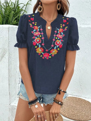 Navy blue embroidered puff sleeve blouse with floral neckline detail and textured fabric.