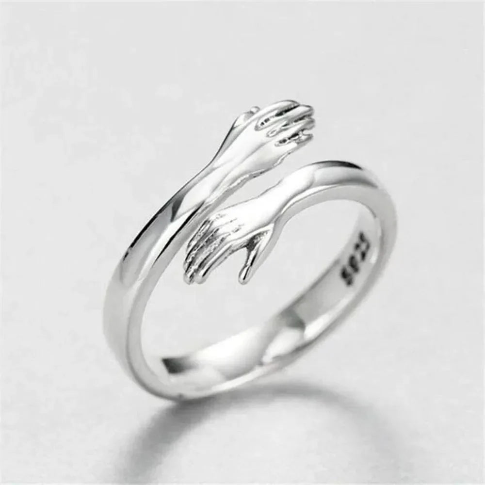 Hugging hands sterling silver ring with adjustable fit and affection design.