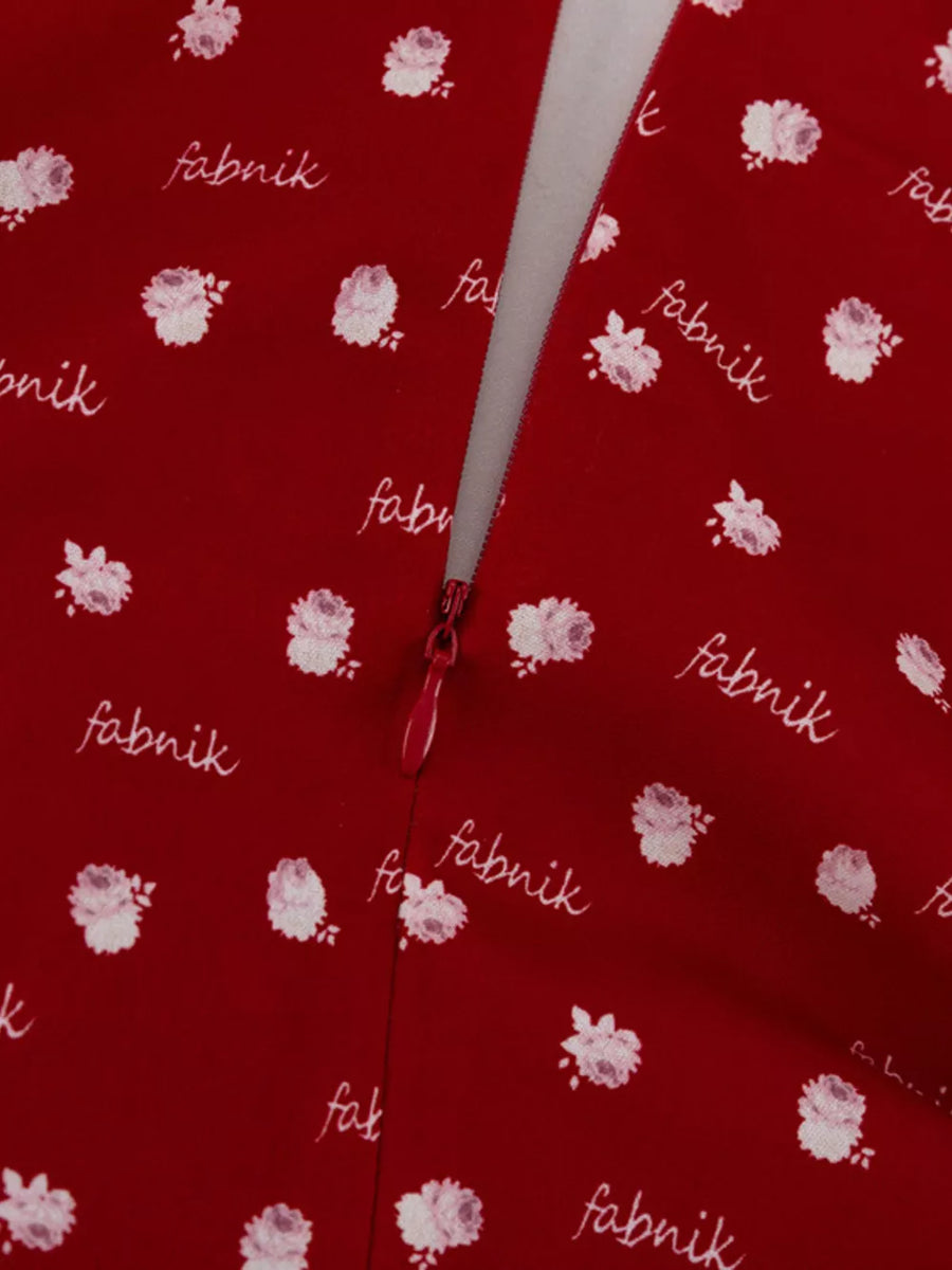 Red floral print dress with white text pattern and zipper detail