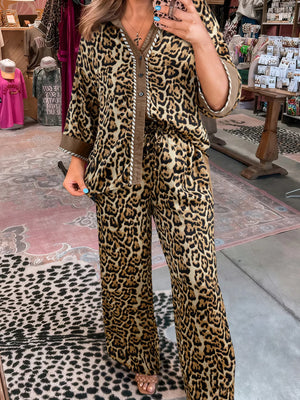 Leopard print two-piece set with buttoned shirt and wide-leg pants.