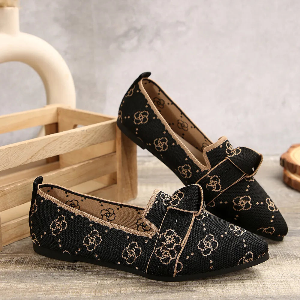 Black knitted pointed flats with allover floral pattern and bow detail