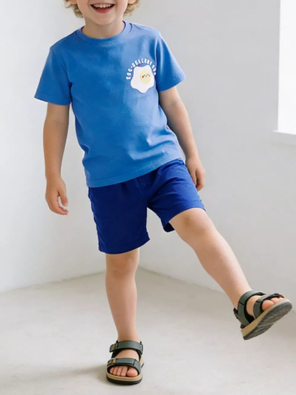 Blue cotton blend toddler t-shirt and shorts set with sunny-side up egg graphic.