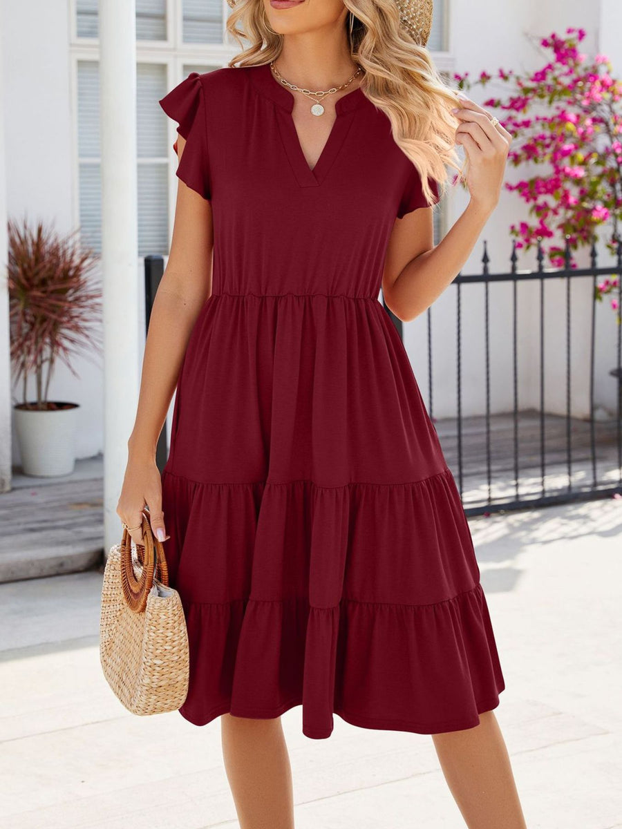 Burgundy ruffled midi dress with notched V-neck and tiered skirt.
