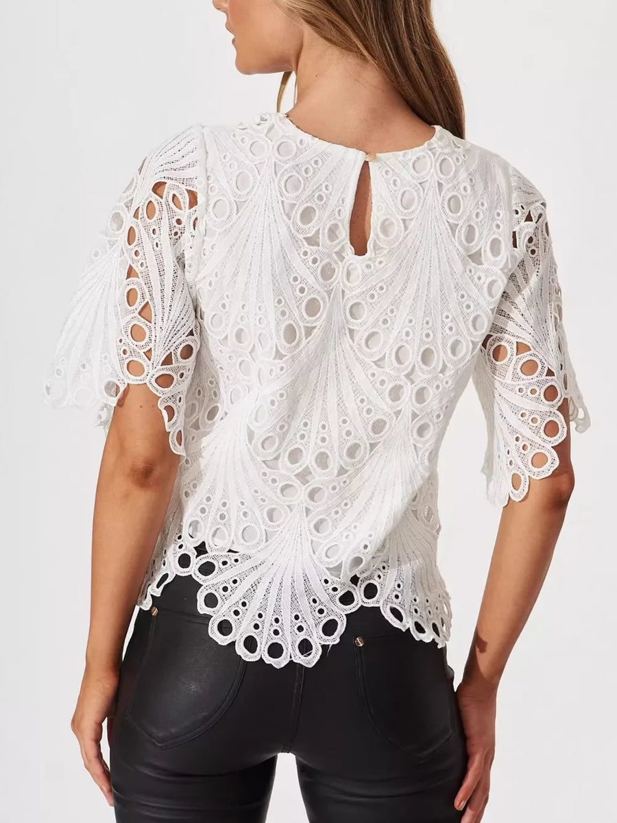 White lace half-sleeve blouse with intricate eyelet pattern and scalloped hem.