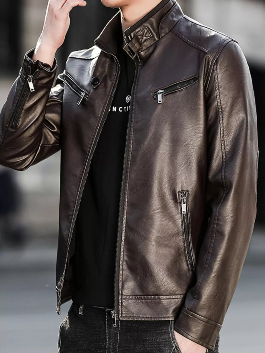 Men's brown leather zip-up jacket with multiple zippered pockets and quilted shoulder detail.