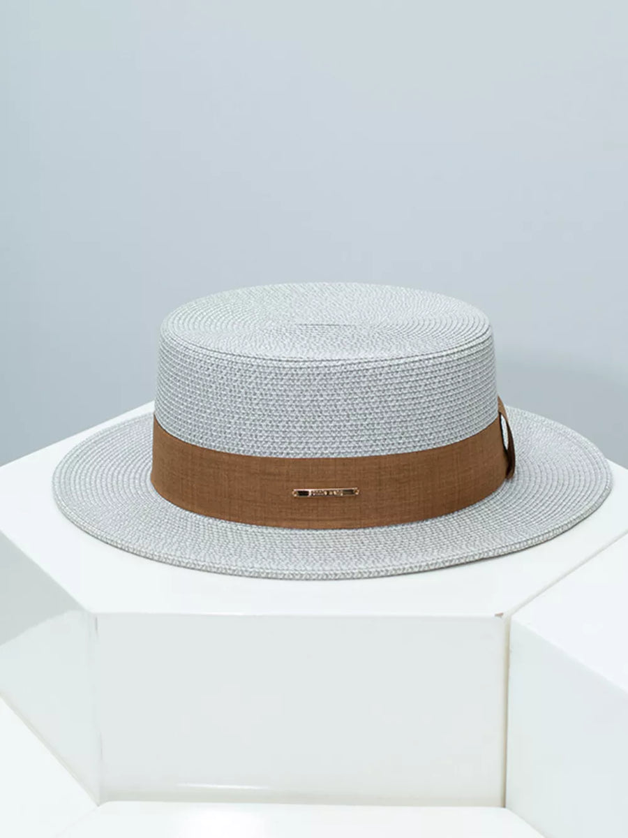 Gray straw boater hat with brown ribbon band and metal detail
