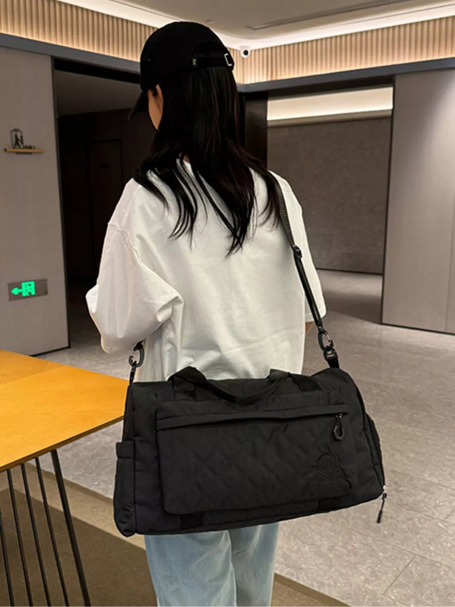 Black diamond-quilted travel bag with versatile straps and multiple pockets.