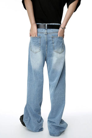 Oversized denim palazzo jeans in medium wash with subtle fading and wide legs.