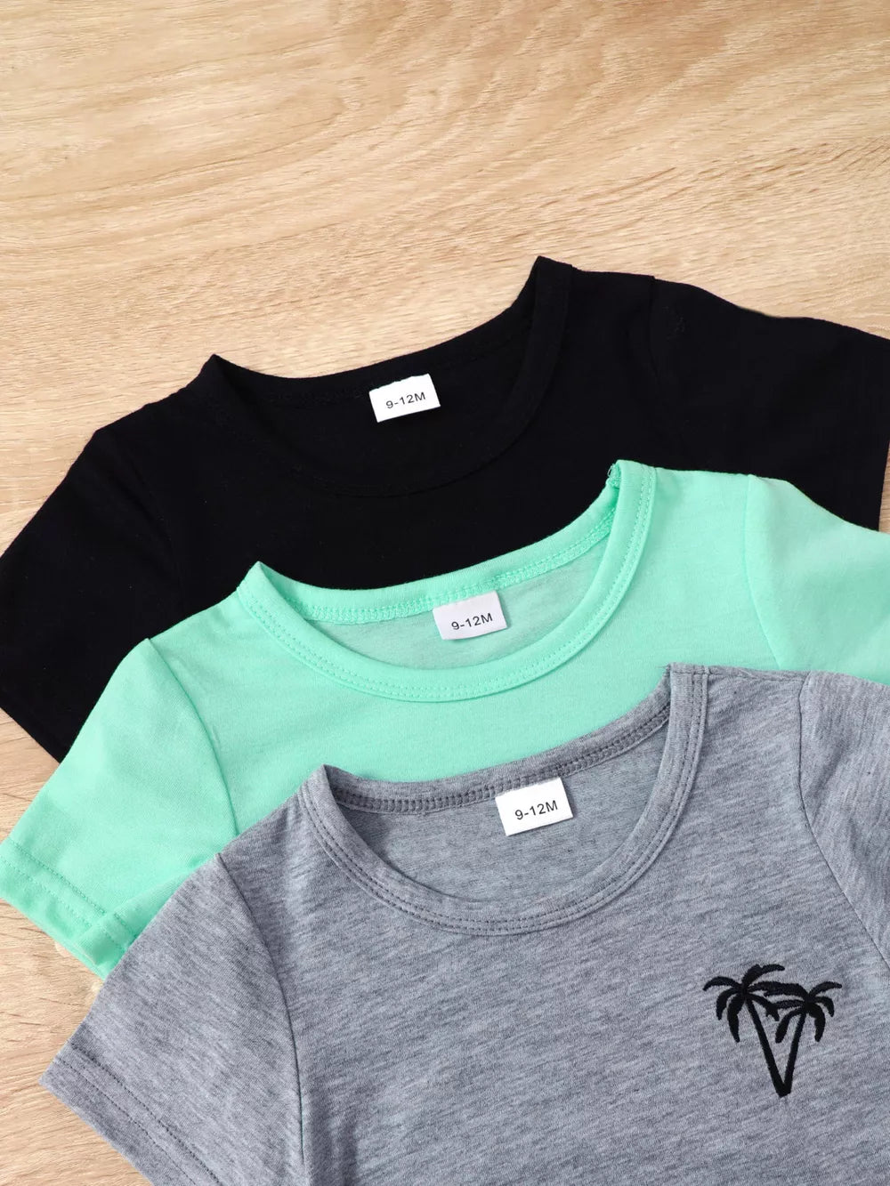 Boys' 4-piece baby set with black, mint green, and grey t-shirts, one with palm tree graphic.