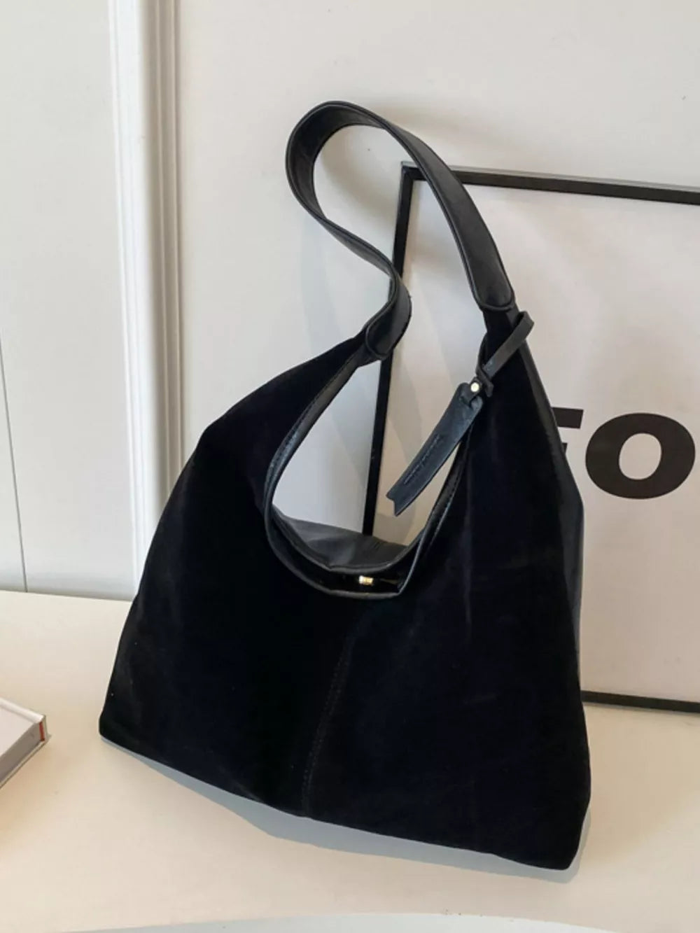 Black plush corduroy hobo shoulder bag with leather strap and gold hardware detail