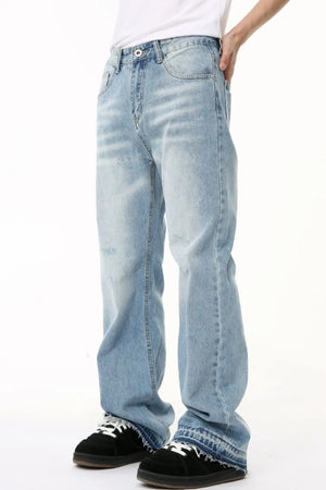 Baggy light wash denim jeans with distressed details and raw hem.
