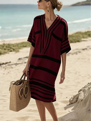 Burgundy striped half sleeve midi dress with V-neck on beach.
