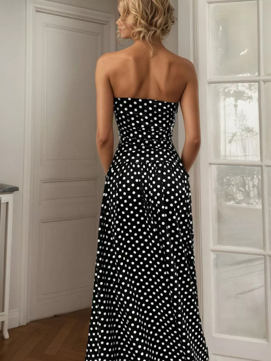 Black polka dot strapless maxi dress with a cinched waist and flowing skirt.