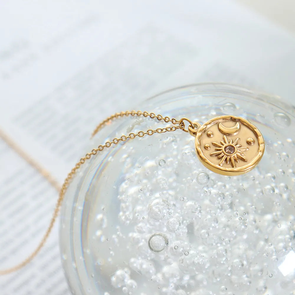 Gold coin necklace with sun, moon, and star details.