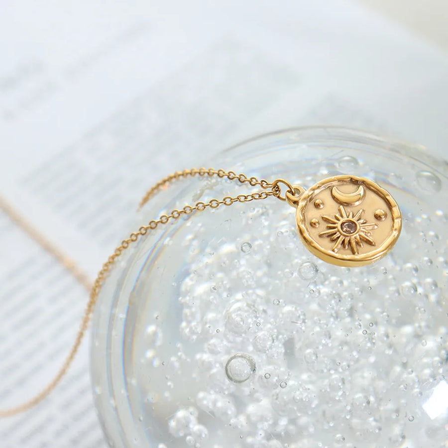 Gold coin necklace with sun, moon, and star details.
