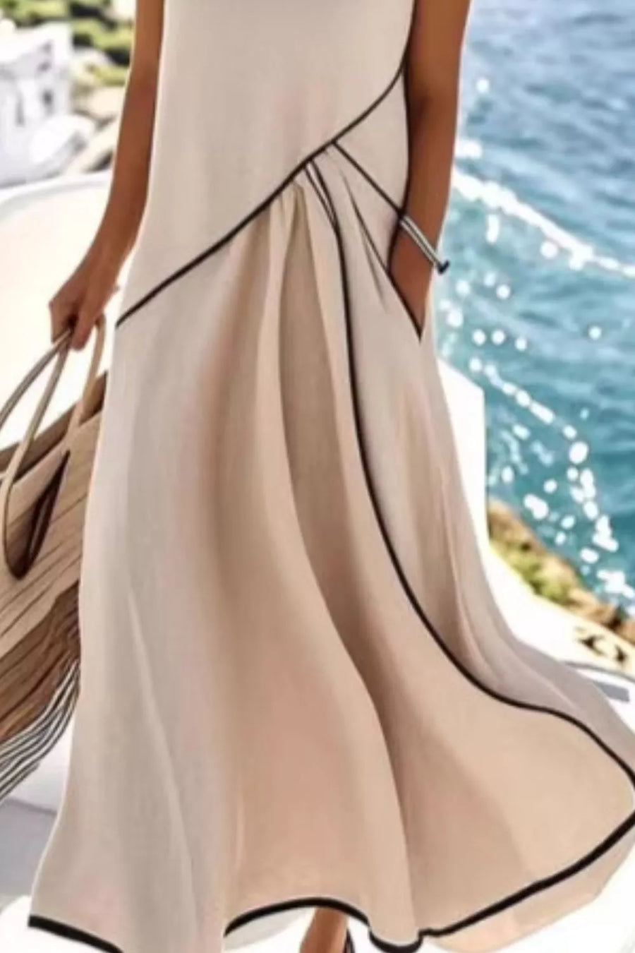 Beige maxi dress with contrast black piping and pockets, flowing skirt.