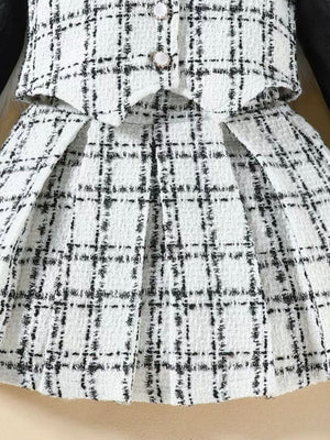 Toddler black and white plaid tweed vest and pleated skirt set with decorative buttons.