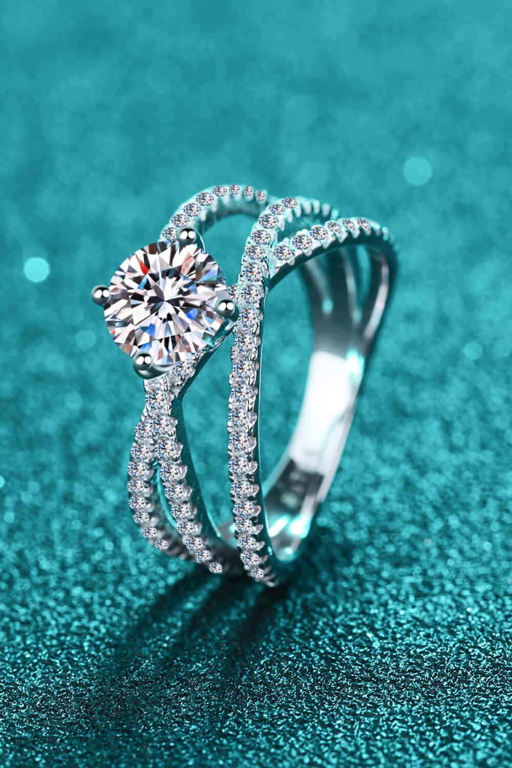 Silver pavé-set crossover engagement ring with a round center stone.