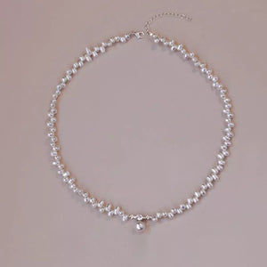 Lustrous irregular pearl pendant necklace with a single pearl drop and crystal accents.