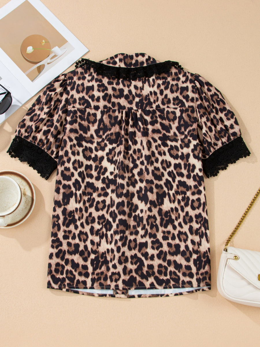 Women's leopard print short sleeve shirt with black lace trim collar and cuffs.