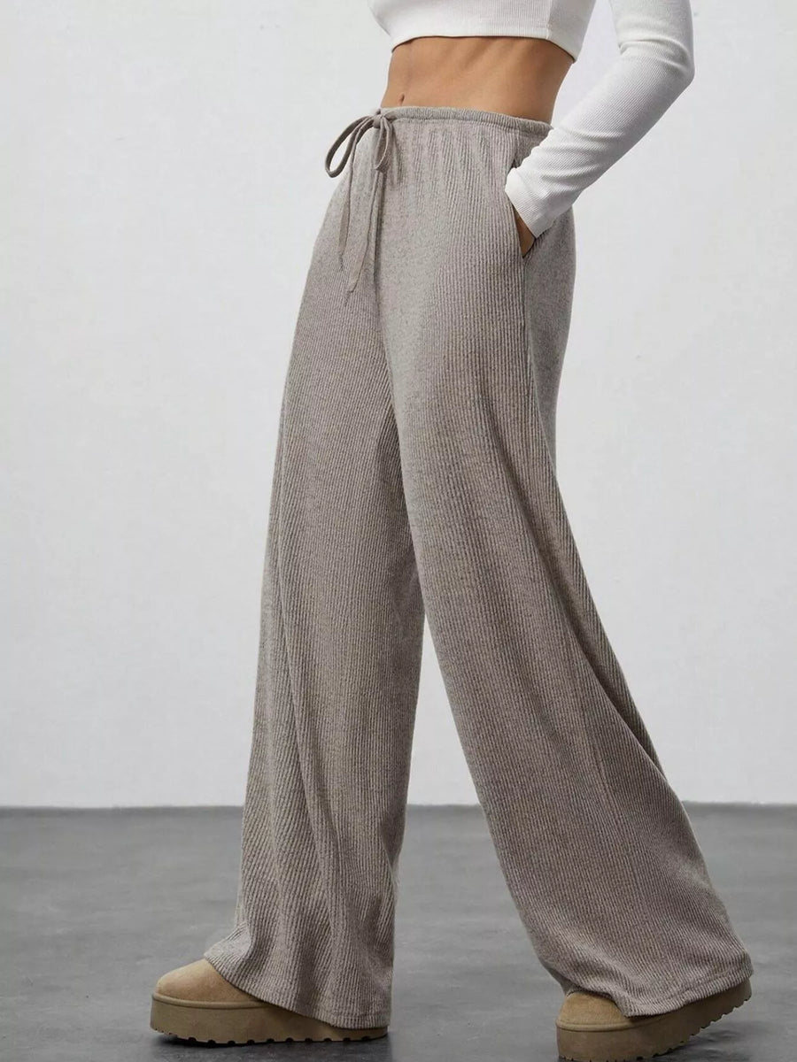 Relaxed wide-leg pants in dark gray with drawstring and ribbed texture.