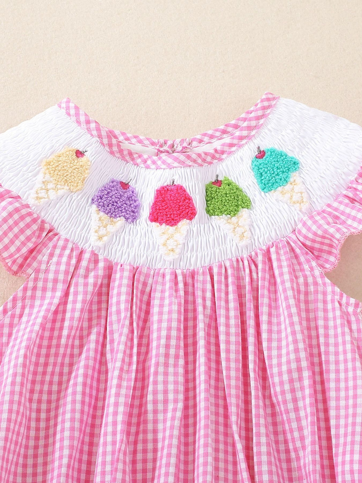 Pink gingham baby one-piece with smocked bodice and embroidered ice cream cones.