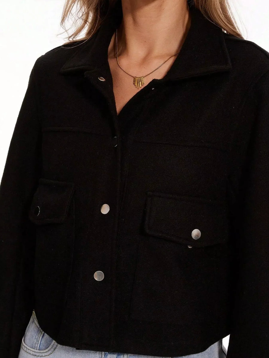 Black trucker jacket with snap buttons and chest pockets.