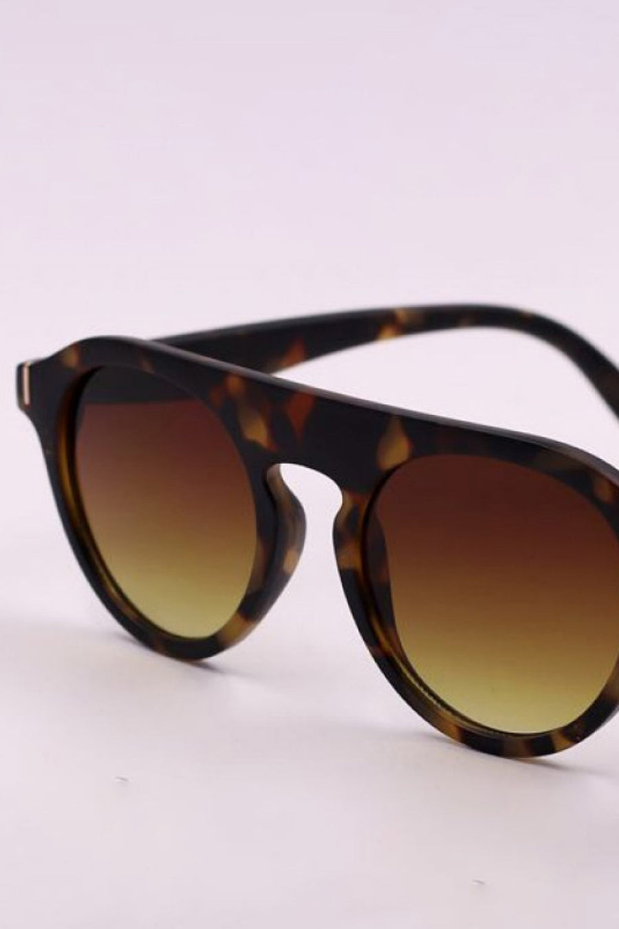 Round frame sunglasses with tortoise shell pattern and gradient brown lenses.