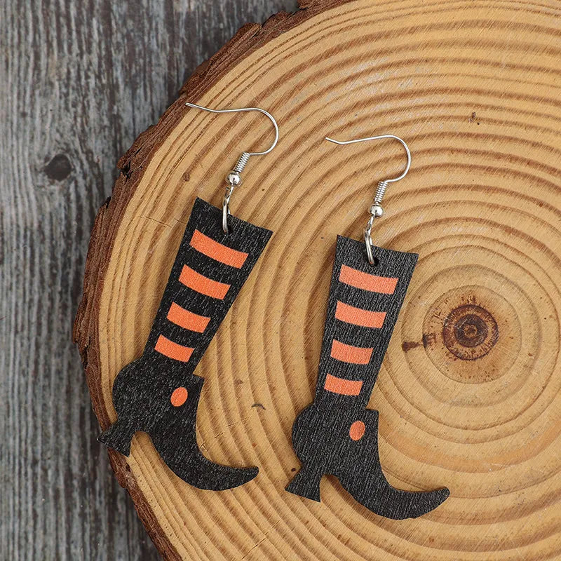 Black witch boot silhouette drop earrings with orange stripes and a small orange dot detail.