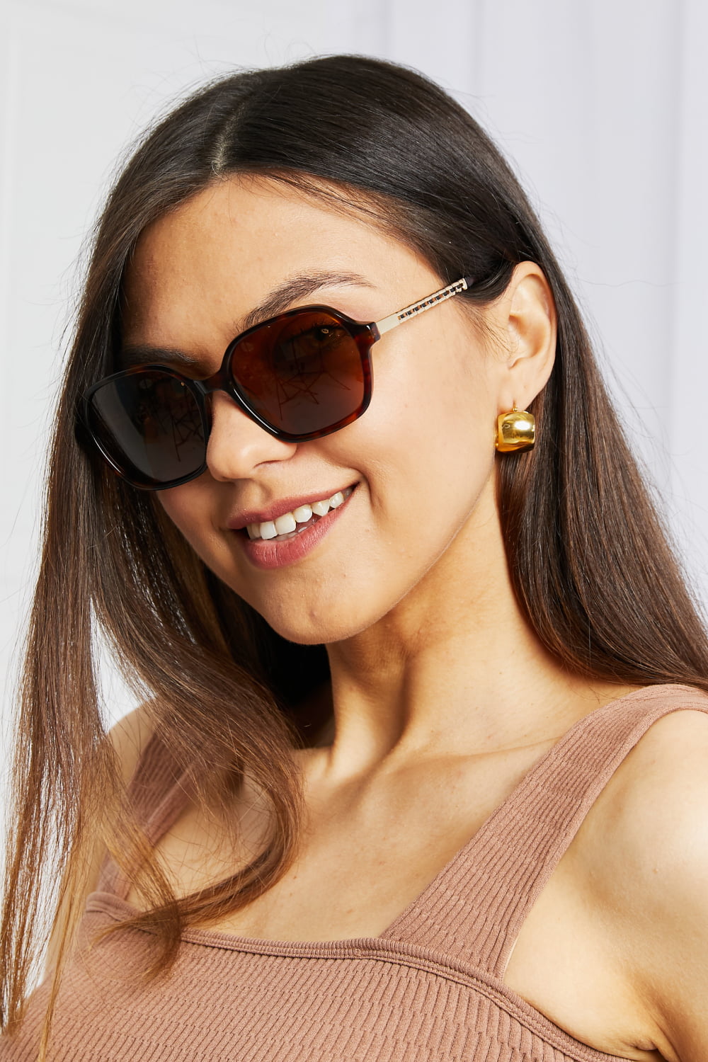 Tortoiseshell hexagonal frame sunglasses with gold temple detail.