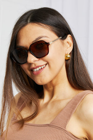Tortoiseshell hexagonal frame sunglasses with gold temple detail.