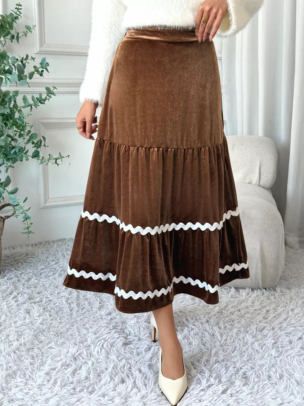 Brown velvet midi skirt with tiered ruffles and white wavy trim detail.