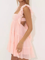 Pink ruffled square neck mini dress with tiered skirt and open back detail.