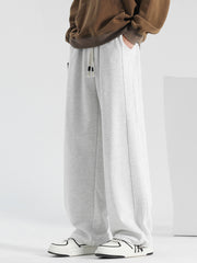 Men's light gray casual drawstring sweatpants with pockets and loose fit.