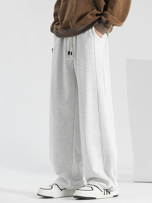 Men's light gray casual drawstring sweatpants with pockets and loose fit.