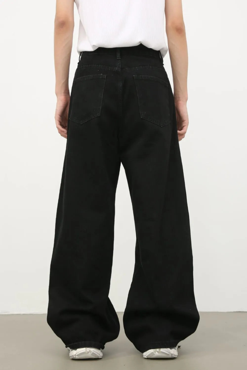 Black denim jeans with exaggerated wide legs and a tie detail
