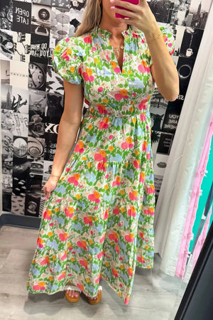 Vibrant floral maxi dress with ruffled neckline, smocked waist, and tiered skirt.