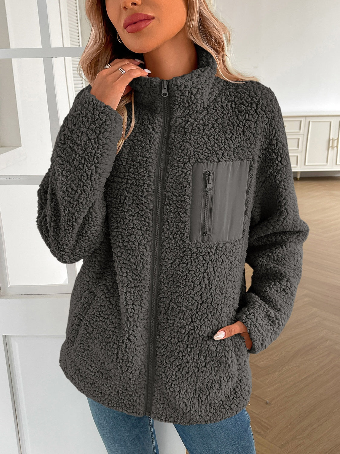 Dark gray teddy fleece jacket with zip closure and patch pocket detail.