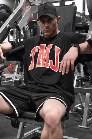 Black oversized graphic tee with red TMJ lettering, athletic fit