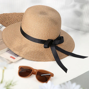 Wide brim straw sun hat in khaki with black bow detail.