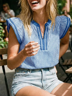 Blue and white striped blouse with ruffle sleeves and split neckline, worn with denim shorts.