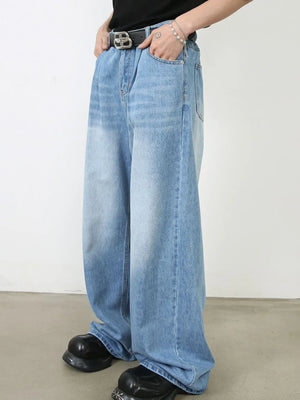 Light blue denim palazzo jeans with pleats and a wide leg, styled with a belt and chunky shoes.
