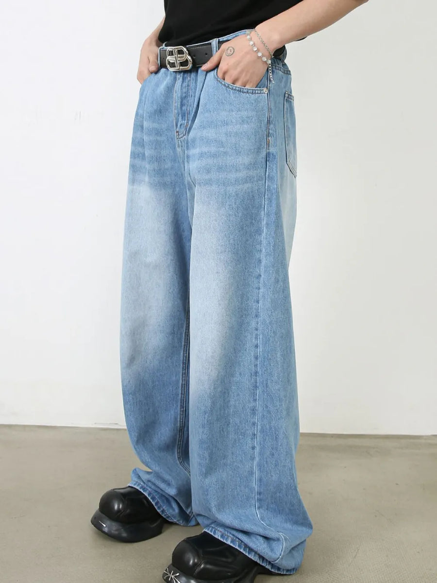 Light blue denim palazzo jeans with pleats and a wide leg, styled with a belt and chunky shoes.