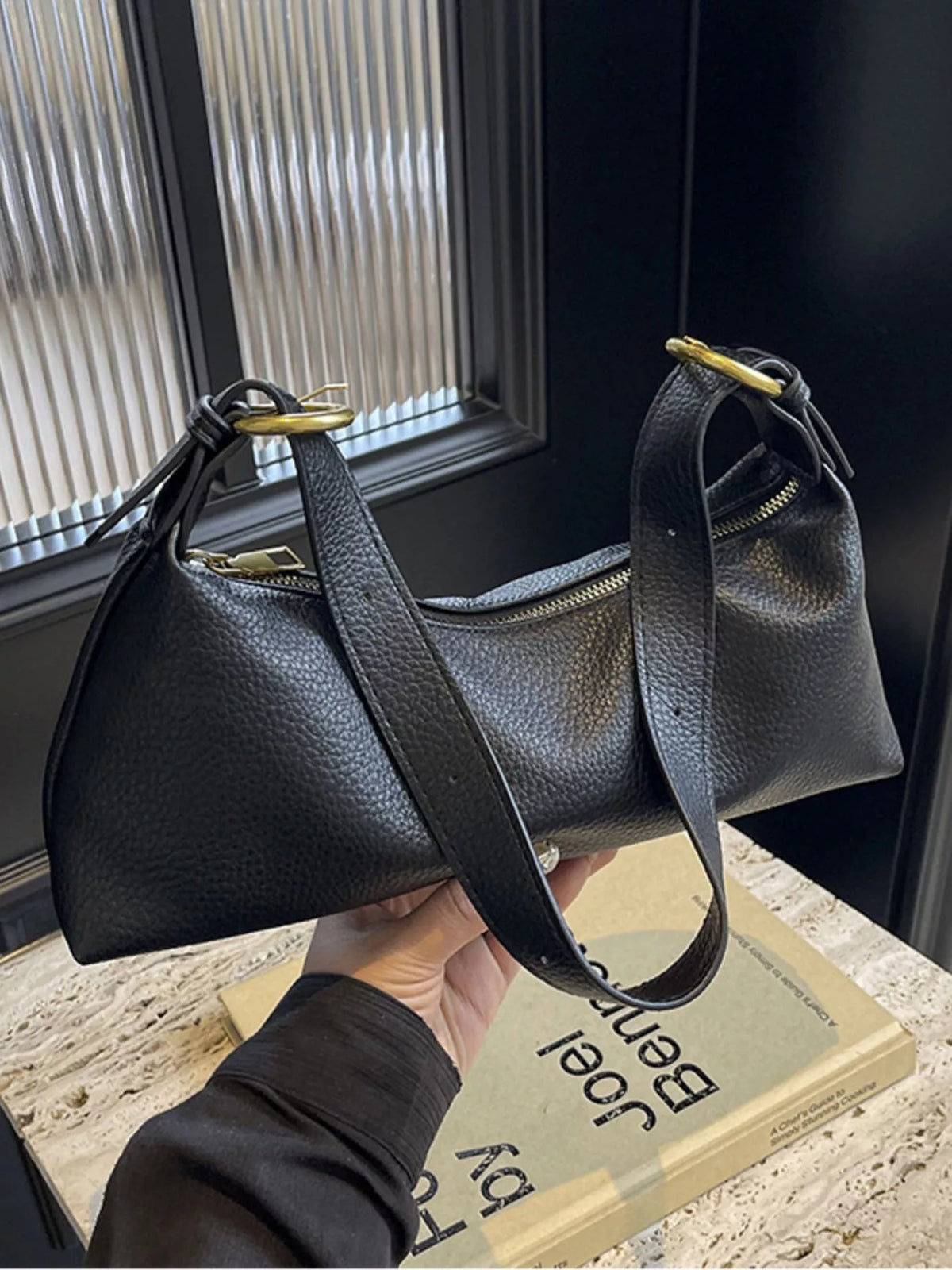 Black pebbled PU leather crossbody bag with gold hardware and adjustable strap.