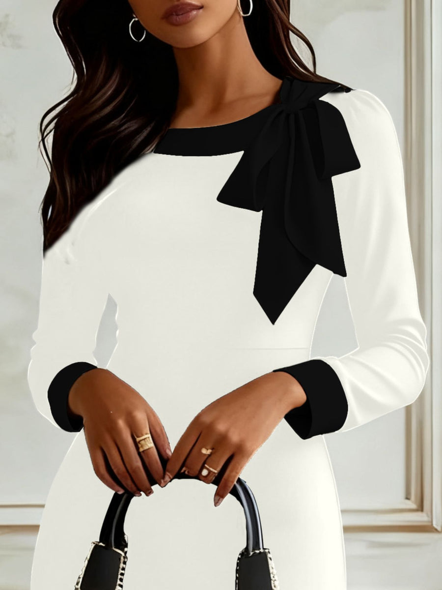 White long sleeve dress with black trim and bowknot detail on shoulder.