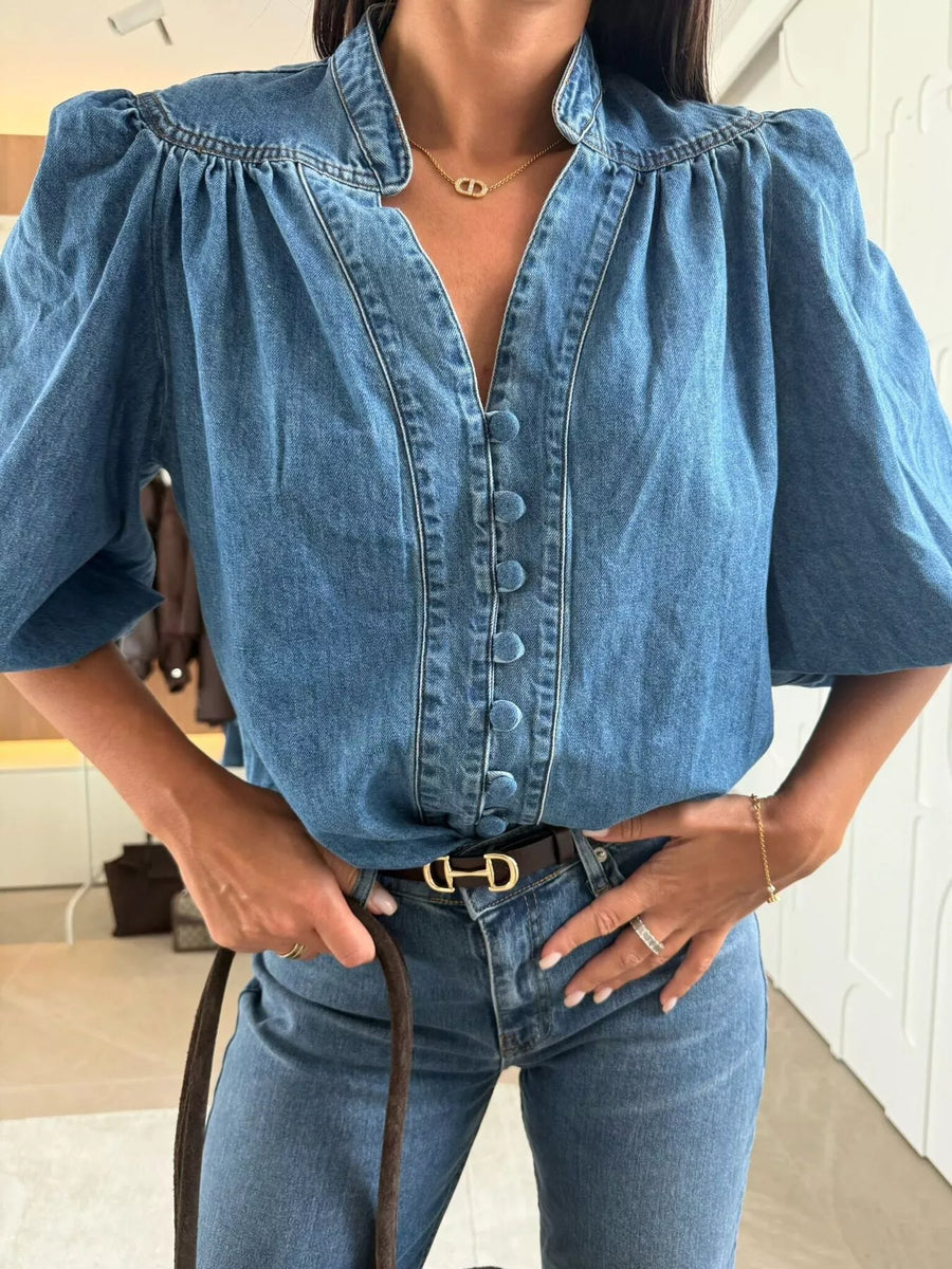 Denim button-down blouse with puff sleeves and a V-neckline.