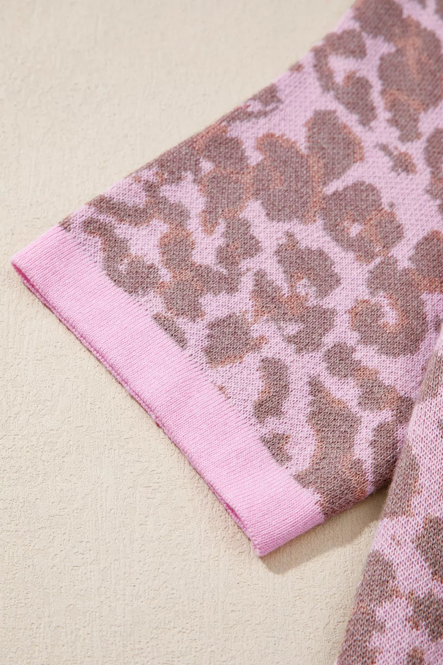 Cardigan with pink and brown leopard print knit fabric and pink trim on the sleeve.